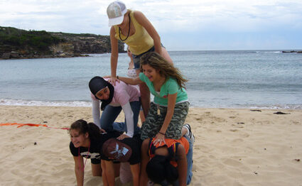 Students forming a human pyramid on beach