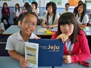 Korean girl together with a girl from a school in Cabramatta reading a book