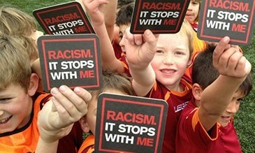 Kids holding signs up stating: Racism. It stops with me