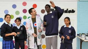 Refugee students in a Sydney high school paint a wall for their school.