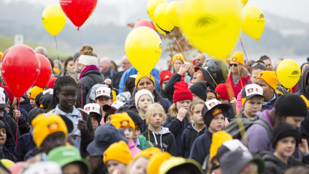 lots of kids walking together with reconciliation ballons