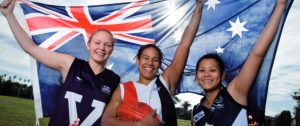 Teenage girls from culturally diverse backgrounds holding an Australian flag