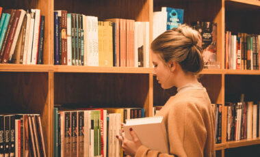 Student looking at books on library shelves