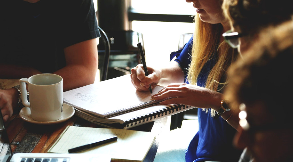 people sitting around table writing