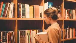 Girl standing in front of large bookshelf