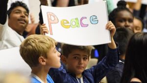 Boy holding peace sign in crowd